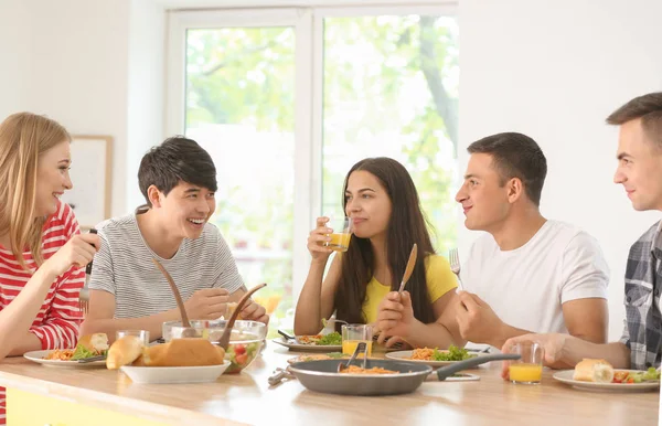 Friends eating at table in kitchen