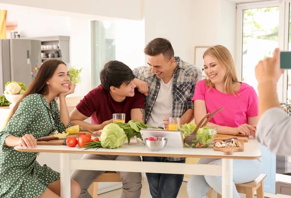 Jovem Tirando Fotos Seus Amigos Cozinha — Fotografia de Stock