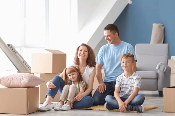 Happy family with cardboard boxes indoors. Moving into new house