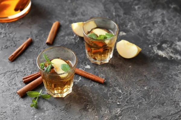 Tasty Drink Cinnamon Apple Slices Glasses Grey Textured Background — Stock Photo, Image