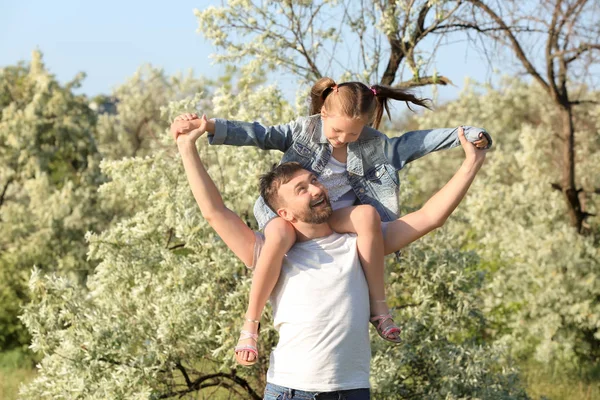 Father playing with little daughter in park