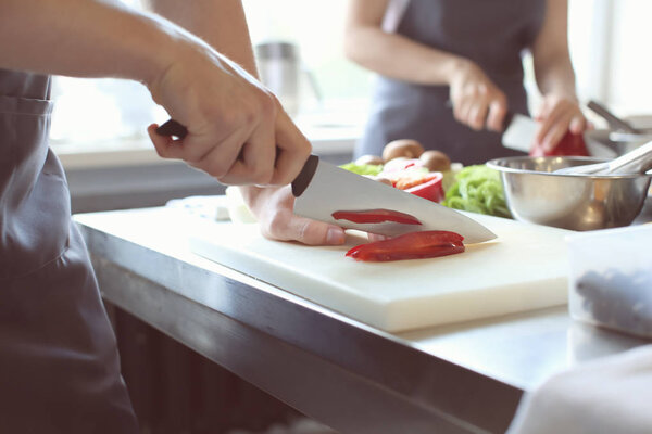 Male chef cutting vegetables in restaurant kitchen