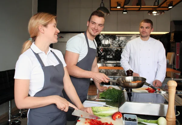 Koch und Gruppe junger Leute bei Kochkursen — Stockfoto