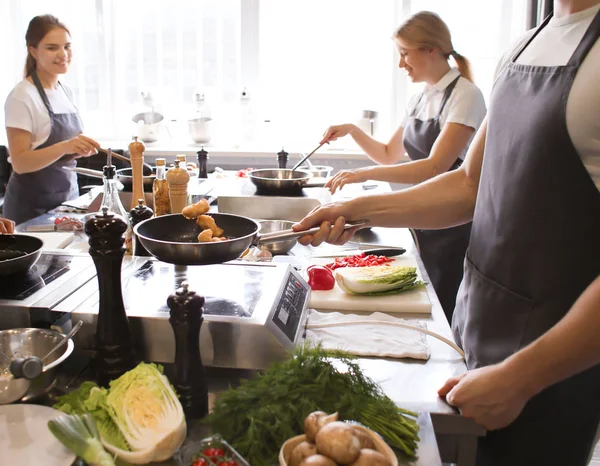 Jonge mensen tijdens de kooklessen in restaurant keuken — Stockfoto