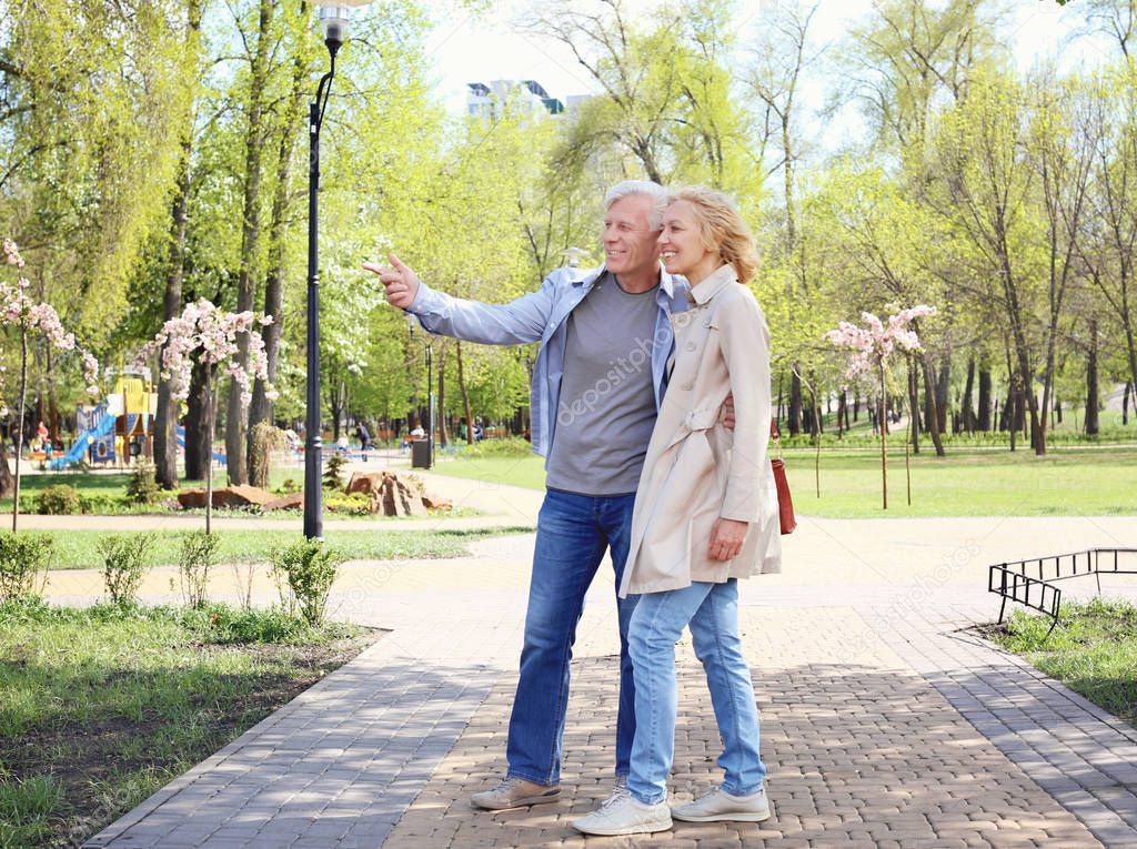 Mature couple walking in park on spring day