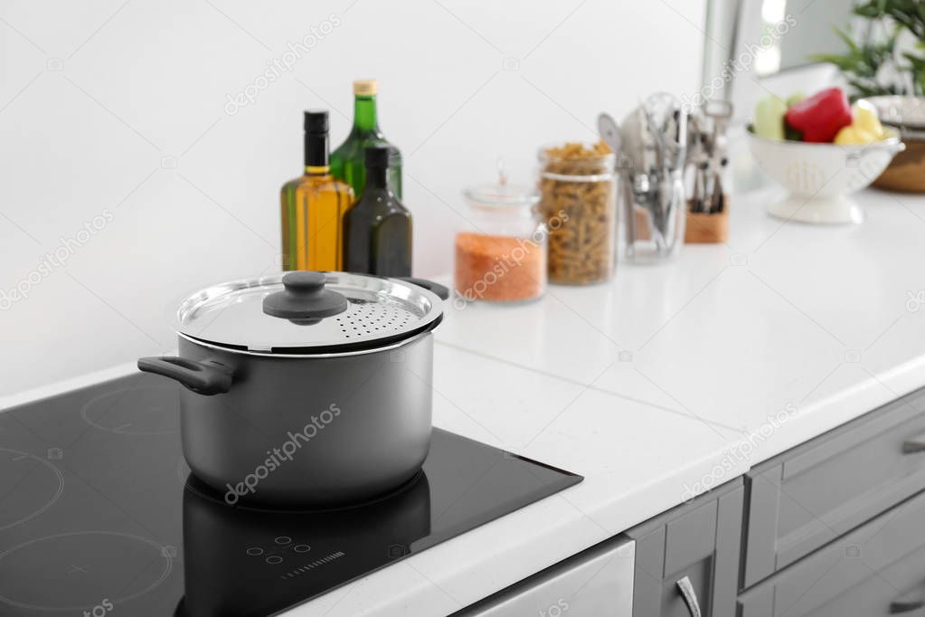 Electric stove with stewpan in kitchen