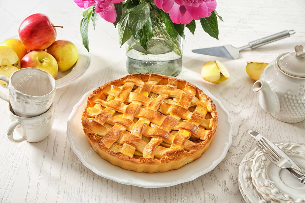 Plate with delicious apple pie on wooden table