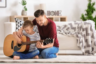 Baba oğlu evde gitar çalmak için öğretim