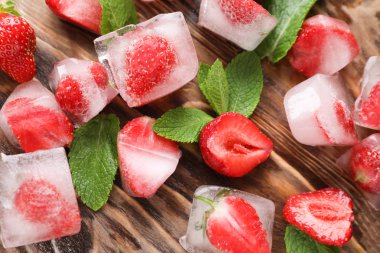 Buz küpleri ile çilek ve ahşap zemin üzerine nane