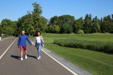 Genç seven ırklararası çift açık havada bahar gününde yürüyüş