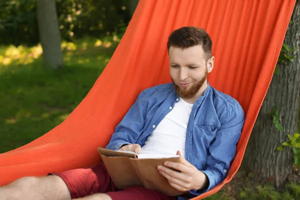 Jonge Man Leesboek Hangmat Buitenshuis — Stockfoto