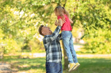 Mutlu baba ve yeşil Parkta oynayan kız