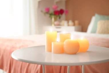 Yatak odasındaki masada mum yakmak.