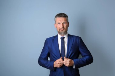 Renk arka plan üzerinde şık elbiseli Olgun yakışıklı