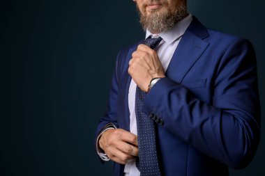 Koyu arka plan üzerinde şık elbiseli Olgun yakışıklı