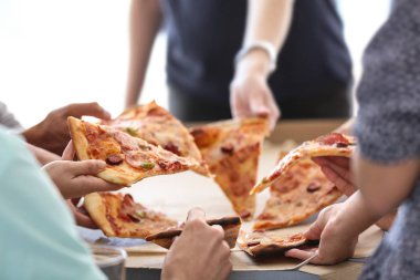 Genç insanlar sıcak lezzetli pizza dilimlerini karton kutu
