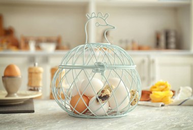 Mutfak masasının üstünde metal sepet tavuk ve Bıldırcın yumurta