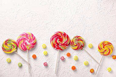 İle lolipop hafif dokulu arka plan üzerinde renkli şekerler