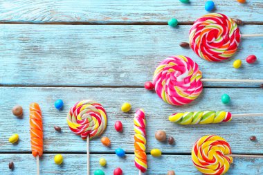 Hafif ahşap arka plan üzerinde renkli lolipop ile kompozisyon