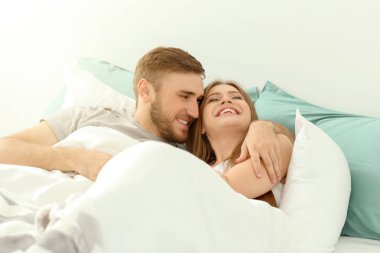 Mutlu genç çift evde yatakta dinleniyor