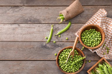 Ahşap masa üzerinde lezzetli taze yeşil bezelye ile kompozisyon