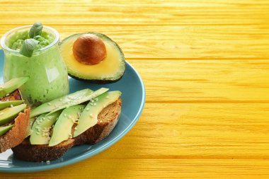 Ekmek dilimlenmiş avokado ve guacamole renk ahşap arka plan üzerinde