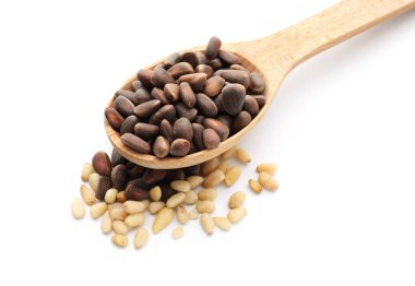 Tahta kaşıkla beyaz zemin üzerine lezzetli çam fıstığı