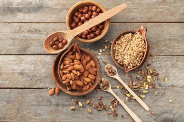 Kase ve kaşık ahşap arka plan üzerinde farklı fındık ile