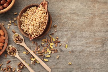 Kase ve kaşık ahşap arka plan üzerinde farklı fındık ile