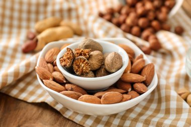 Ahşap masa üzerinde farklı fındık ile kase