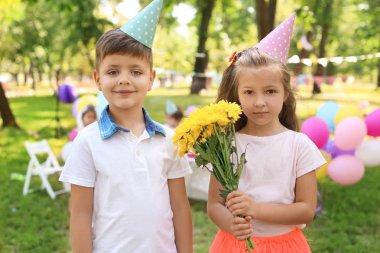 Çiçek ve yakışıklı açık havada Doğum günü partisinde küçük kız