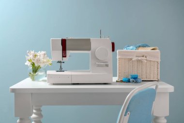 Tablo renkli arka plan üzerinde modern dikiş makinesi ile