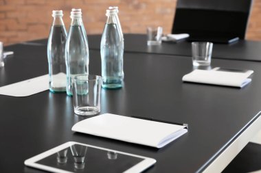 Şişe su ve konferans salonu iş toplantısı için hazırlanan tablet içeren tablo
