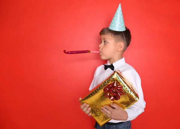 Симпатичный Мальчик Праздничным Свистком Подарком День Рождения Цветном Фоне — стоковое фото