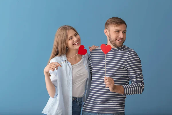 色の背景に赤いハートの幸せな若いカップル — ストック写真