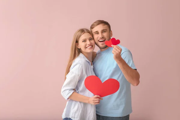 快乐的年轻夫妇 与红色的心 在彩色背景 — 图库照片