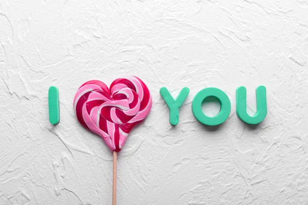 Phrase I LOVE YOU made of lollipop and letters on light textured background