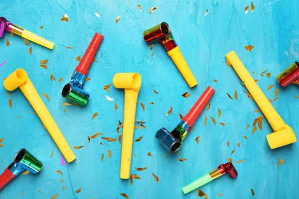 Birthday party whistles on color background