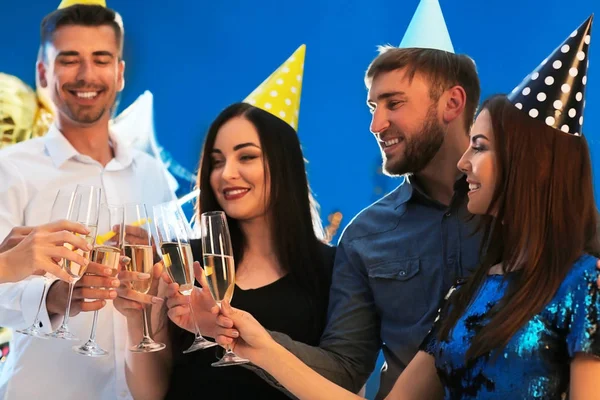 Young people with glasses of champagne at birthday party in club