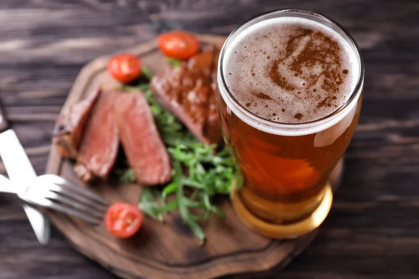 Holzbrett Mit Leckerem Steak Vom Grill Und Einem Glas Bier — Stockfoto