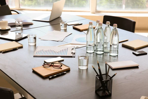 Table with bottles of water prepared for business meeting in conference hall