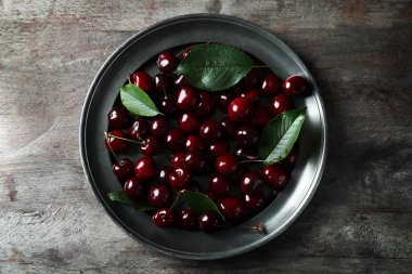 Olgun kiraz ahşap arka plan üzerinde plaka