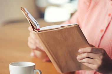 Genç kadın okuma kitabı kafe, portre