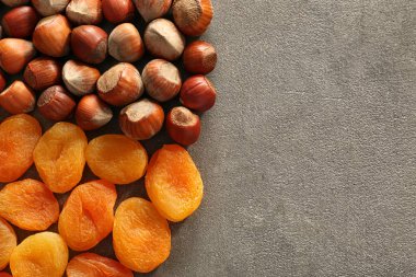 Gri dokulu arka plan üzerinde kuru kayısı ile fındık