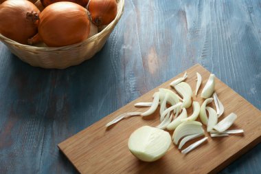 Ahşap tahta masada dilimlenmiş ve bütün soğan ile