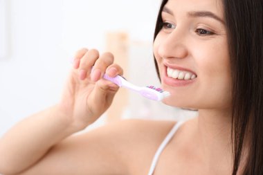 genç kadın banyoda diş fırçalama