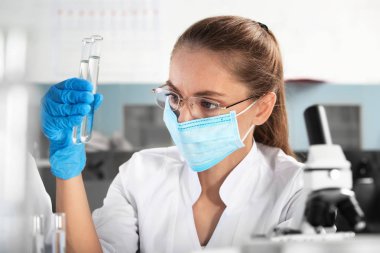 Laboratuarda test tüpleri örnekleri ile tutan bilim adamı