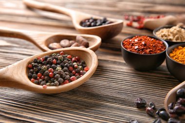 Kaşık ve kaseler ile ahşap arka plan, closeup üzerinde farklı kuru baharat