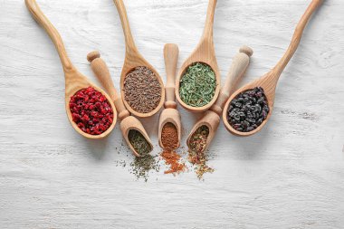 Kaşık ve kepçe ile ahşap arka plan üzerinde farklı kuru baharat