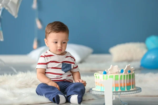 部屋にふわふわの敷物の上に座っての誕生日ケーキとかわいい男の子 — ストック写真